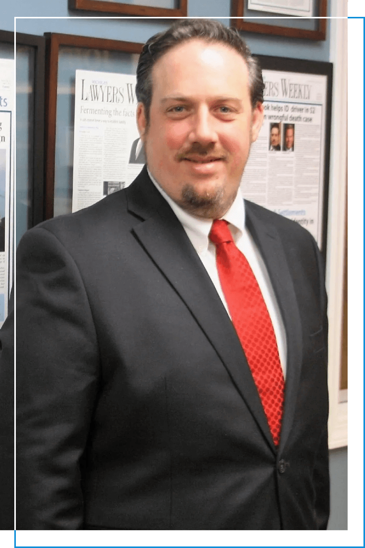 A man in a suit and tie standing next to a wall.