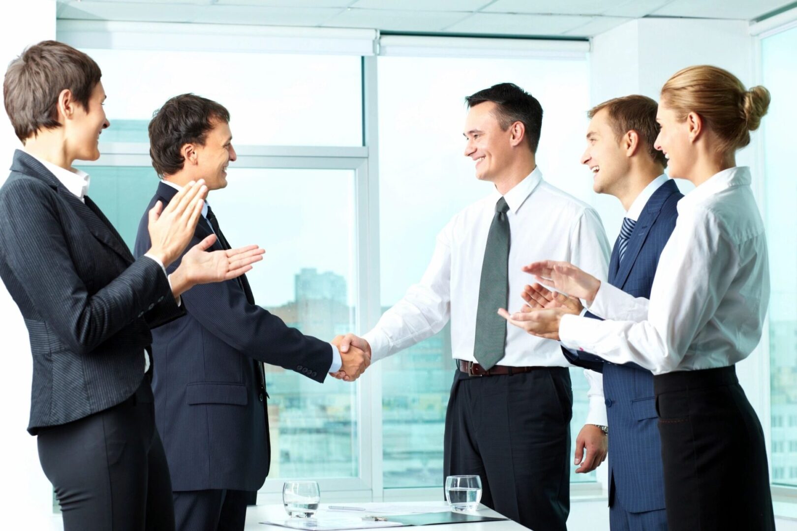 A group of people in suits shaking hands.