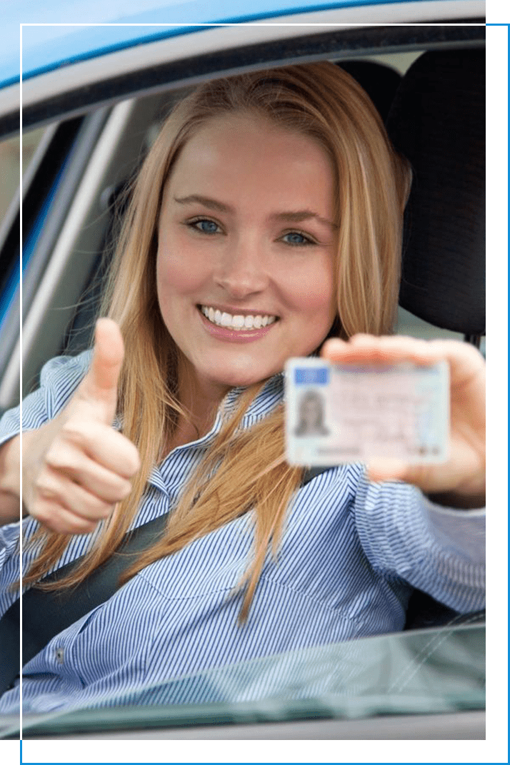 A woman holding up her driver 's license in the car.